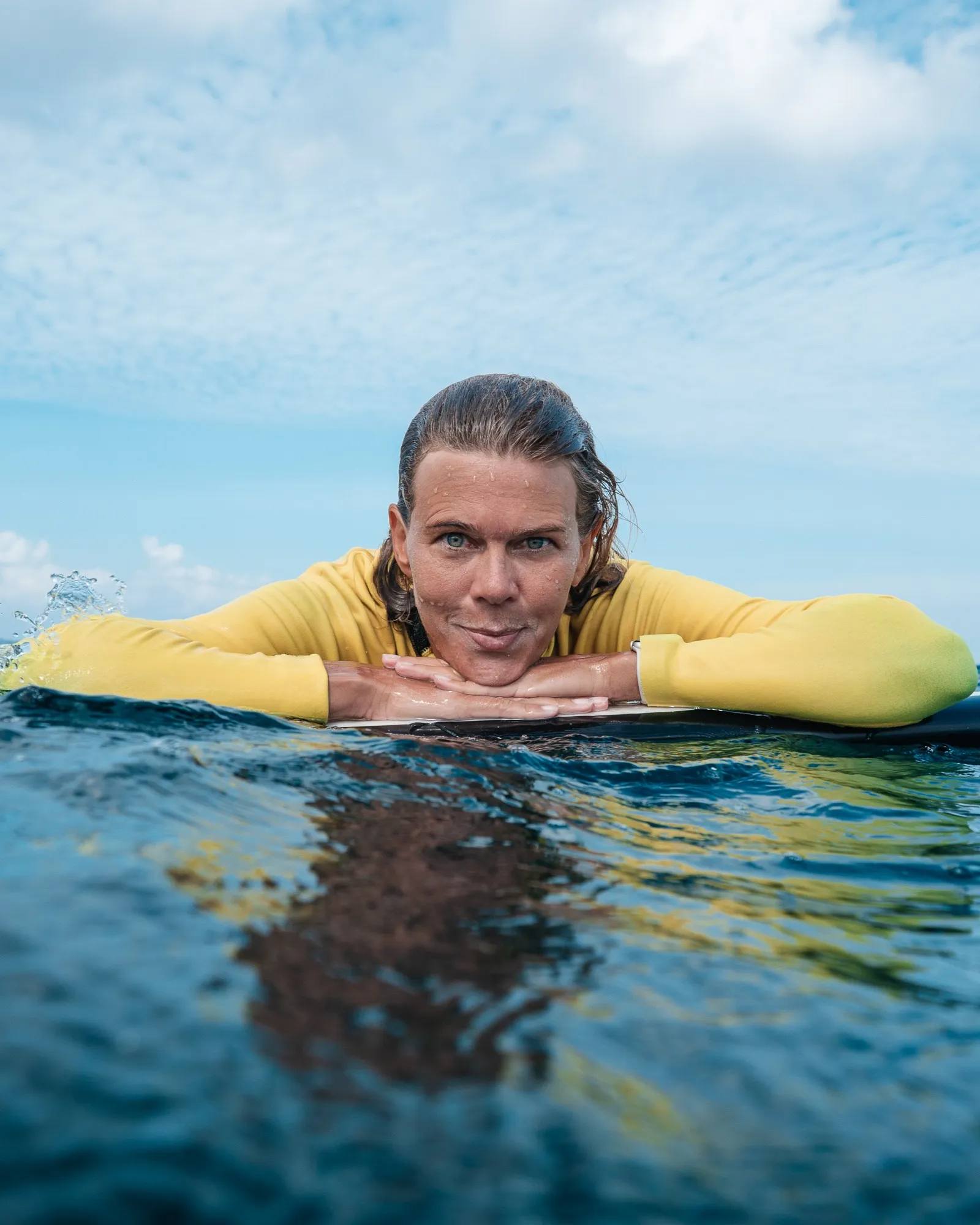 Lisa Davidsson resting on a surfboard in the ocean